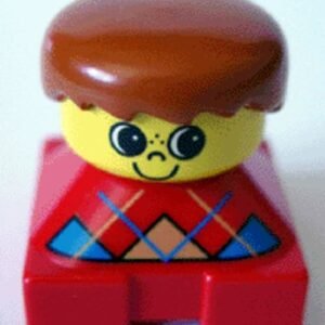 2327pb08 – Duplo 2 x 2 x 2 Figure Brick, Red Base with Blue Argyle Sweater Pattern, Yellow Head with Freckles on Nose, Dark Orange Male Hair